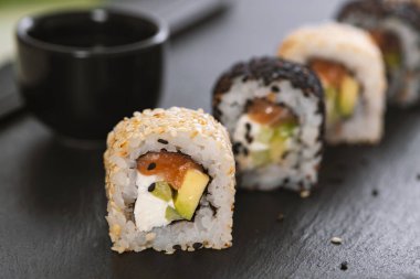 Pilavlı suşi, salatalık, avokado, somon, susam. Suşi menüsü. Japon yemeği..