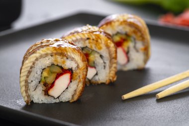 Pilavlı suşi, yengeç, salatalık, avokado, tobiko, yılan balığı. Suşi menüsü. Japon yemeği..