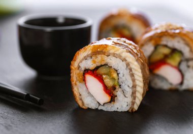 Pilavlı suşi, yengeç, salatalık, avokado, tobiko, yılan balığı. Suşi menüsü. Japon yemeği..