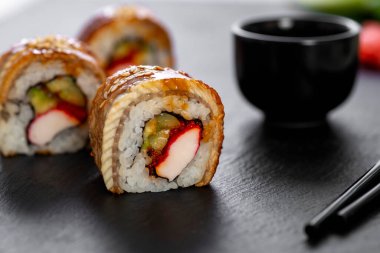 Pilavlı suşi, yengeç, salatalık, avokado, tobiko, yılan balığı. Suşi menüsü. Japon yemeği..