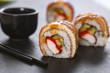 Pilavlı suşi, yengeç, salatalık, avokado, tobiko, yılan balığı. Suşi menüsü. Japon yemeği..