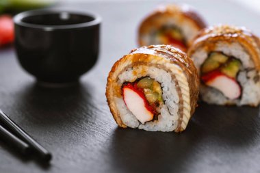 Pilavlı suşi, yengeç, salatalık, avokado, tobiko, yılan balığı. Suşi menüsü. Japon yemeği..