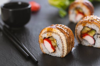 Pilavlı suşi, yengeç, salatalık, avokado, tobiko, yılan balığı. Suşi menüsü. Japon yemeği..