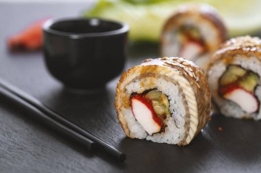 Pilavlı suşi, yengeç, salatalık, avokado, tobiko, yılan balığı. Suşi menüsü. Japon yemeği..