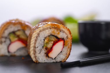 Pilavlı suşi, yengeç, salatalık, avokado, tobiko, yılan balığı. Suşi menüsü. Japon yemeği..
