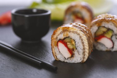 Pilavlı suşi, yengeç, salatalık, avokado, tobiko, yılan balığı. Suşi menüsü. Japon yemeği..