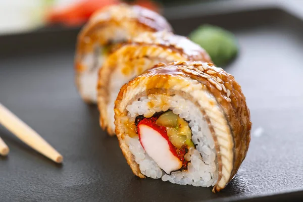 Pilavlı suşi, yengeç, salatalık, avokado, tobiko, yılan balığı. Suşi menüsü. Japon yemeği..