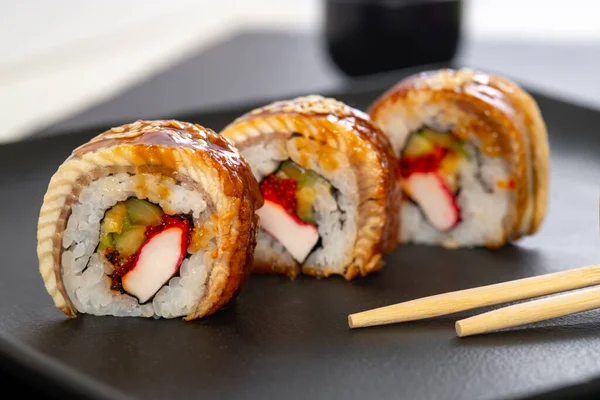 Sushi roll with rice, crab, cucumber, avocado ,tobiko, eel. Sushi menu. Japanese food.