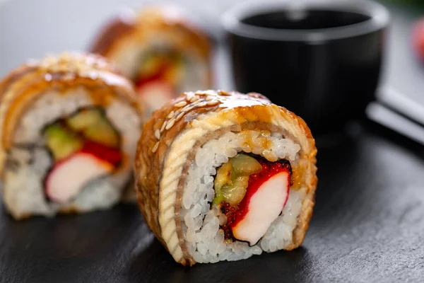 Sushi roll with rice, crab, cucumber, avocado ,tobiko, eel. Sushi menu. Japanese food.