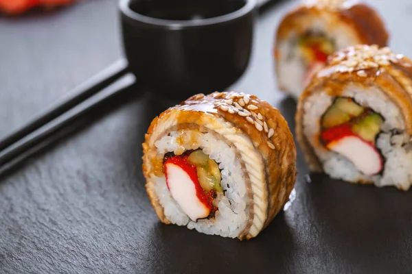 Pilavlı suşi, yengeç, salatalık, avokado, tobiko, yılan balığı. Suşi menüsü. Japon yemeği..