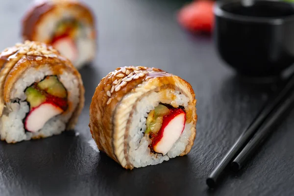 Pilavlı suşi, yengeç, salatalık, avokado, tobiko, yılan balığı. Suşi menüsü. Japon yemeği..