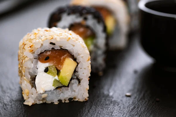 Sushi roll with rice, cucumber, avocado ,salmon, sesame. Sushi menu. Japanese food.