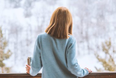 Kadın bir termos şişe elinde bir kış ormanda arka planda