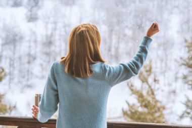 Kadın bir termos şişe elinde bir kış ormanda arka planda
