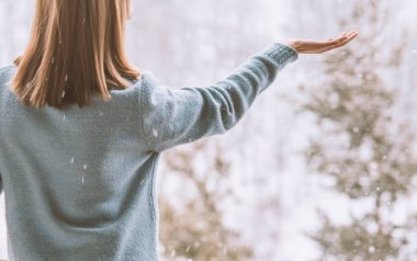 Kadın kar tanelerini yakalıyor, kış vuruşu.