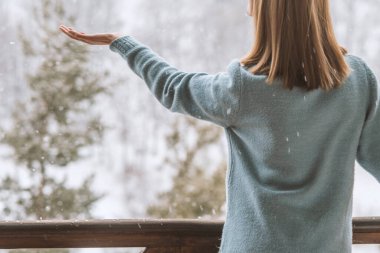 Kadın kar tanelerini yakalıyor, kış vuruşu.
