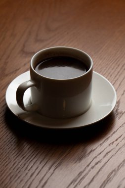 bir fincan kahve ahşap bir masaya. seçici odak.