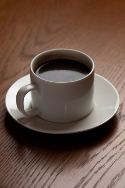 bir fincan kahve ahşap bir masaya. seçici odak.