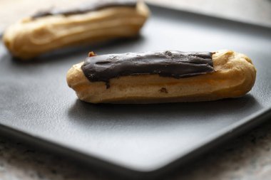 Siyah bir tabakta çikolata ekleriName .