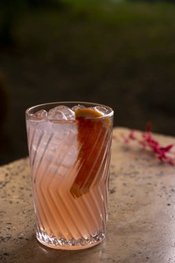 Bardakta kokteyl, taştan bir masada pipet..