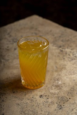Bardakta kokteyl, taştan bir masada pipet..