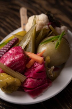 Tahta masadaki bir tabakta sebze turşusu..