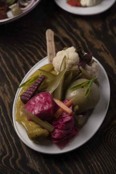 Tahta masadaki bir tabakta sebze turşusu..