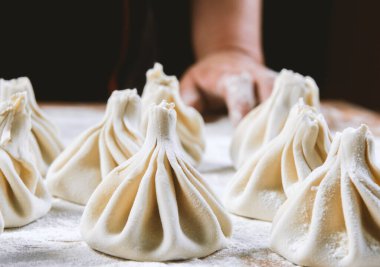Aşçı ahşap masada khinkali yapıyor. İşlem hazırlığı Gürcistan yemeği. yiyecek konsepti.