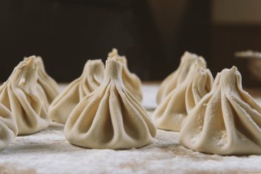 Aşçı ahşap masada khinkali yapıyor. İşlem hazırlığı Gürcistan yemeği. yiyecek konsepti.