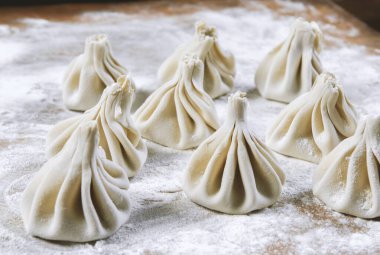 Aşçı ahşap masada khinkali yapıyor. İşlem hazırlığı Gürcistan yemeği. yiyecek konsepti.