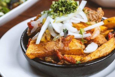 Beef stew with potatoes, carrots and herbs on black background with copy