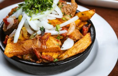 Beef stew with potatoes, carrots and herbs on black background with copy