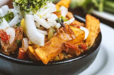 Beef stew with potatoes, carrots and herbs on black background with copy
