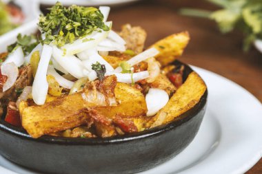 Beef stew with potatoes, carrots and herbs on black background with copy