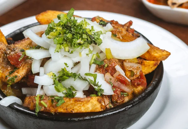 Beef stew with potatoes, carrots and herbs on black background with copy
