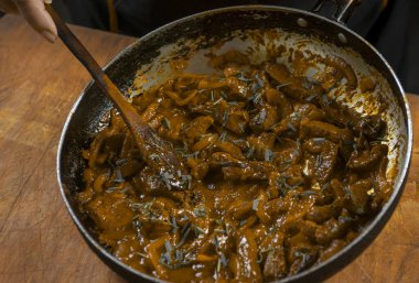 Aşçı eti sebzeli ve soğanlı bir kasede hazırlar. Doğu mutfağı.