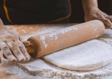 Pizza hazırlamak için hamur yoğuruyorum. Aşçı ahşap masada turta pişirmek için hamur yapıyor. İşlem hazırlığı ev yapımı hamur işi. Makarna, ekmek, spagetti, khachapuri, yemek konsepti.