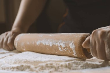 Pizza hazırlamak için hamur yoğuruyorum. Aşçı ahşap masada turta pişirmek için hamur yapıyor. İşlem hazırlığı ev yapımı hamur işi. Makarna, ekmek, spagetti, khachapuri, yemek konsepti.