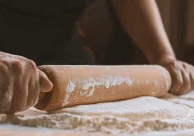 Pizza hazırlamak için hamur yoğuruyorum. Aşçı ahşap masada turta pişirmek için hamur yapıyor. İşlem hazırlığı ev yapımı hamur işi. Makarna, ekmek, spagetti, khachapuri, yemek konsepti.