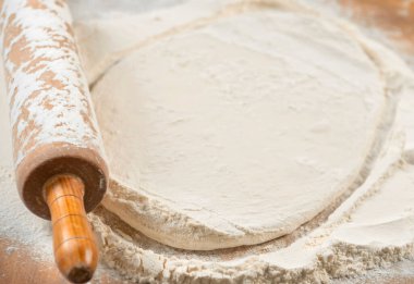 Pizza hazırlamak için hamur yoğuruyorum. Aşçı ahşap masada turta pişirmek için hamur yapıyor. İşlem hazırlığı ev yapımı hamur işi. Makarna, ekmek, spagetti, khachapuri, yemek konsepti.