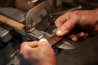 Avcı bıçağı yapan bir zanaatkârın yakın çekimi..