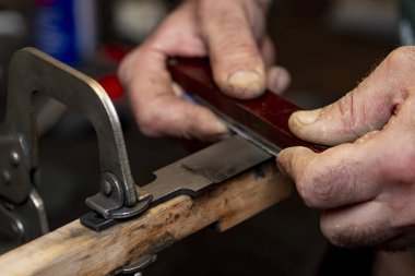 Avcı bıçağı yapan bir zanaatkârın yakın çekimi..