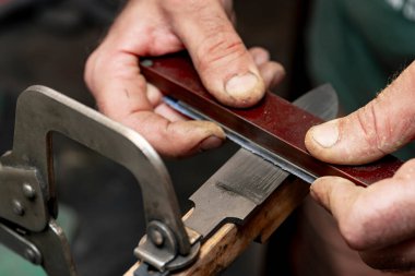Avcı bıçağı yapan bir zanaatkârın yakın çekimi..