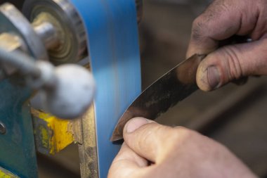 Avcı bıçağı yapan bir zanaatkârın yakın çekimi..