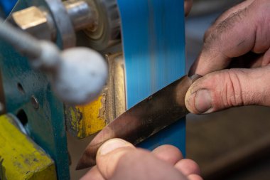 Avcı bıçağı yapan bir zanaatkârın yakın çekimi..