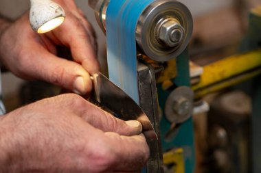 Avcı bıçağı yapan bir zanaatkârın yakın çekimi..