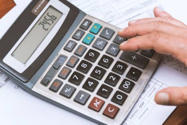 Hesap makinesi masadayken elinizi kapatın. İş konsepti.