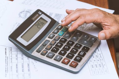 Hesap makinesi masadayken elinizi kapatın. İş konsepti.