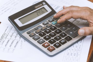 Hesap makinesi masadayken elinizi kapatın. İş konsepti.