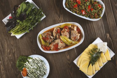 Oryantal yemek khashlama, salata, peynir ve otlar ahşap bir masada..